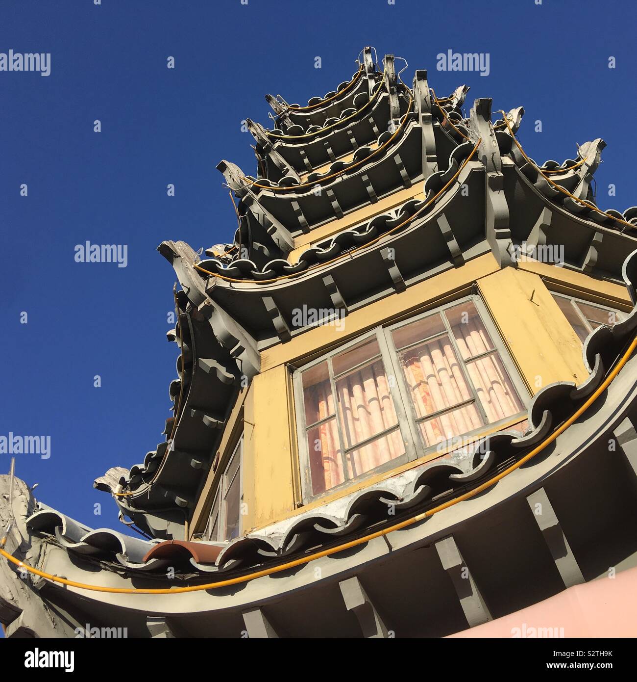 LOS ANGELES, CA, JUL 2019: looking up at pagoda-style building in Chinatown, deep blue sky in background - Smartphone Captured Stock Image