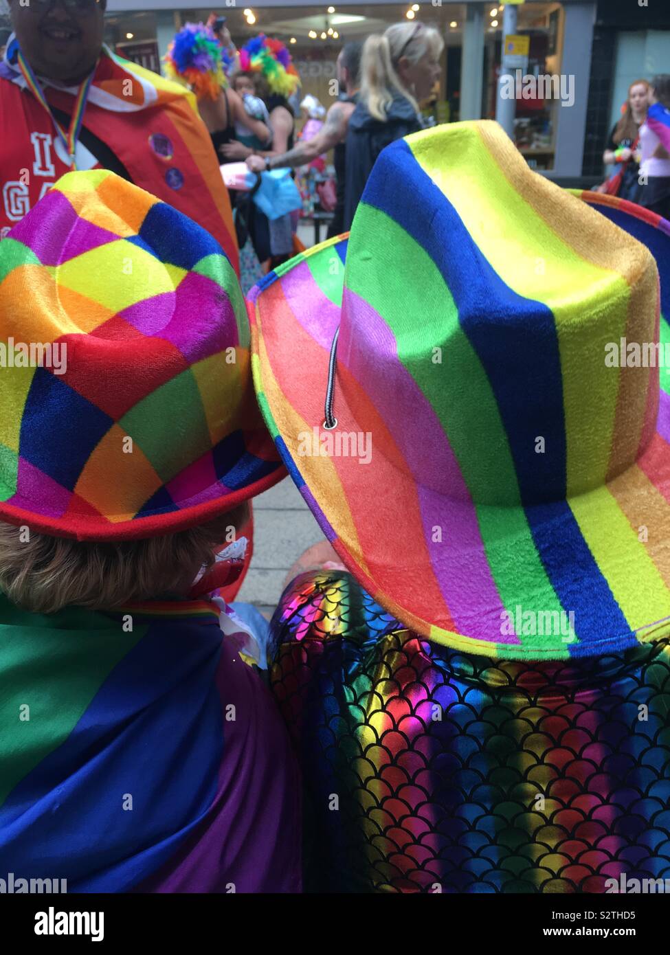 Two people sit watching the Nottinghamshire Pride celebrations on Saturday 27 July in Nottingham City Centre. Stock Photo