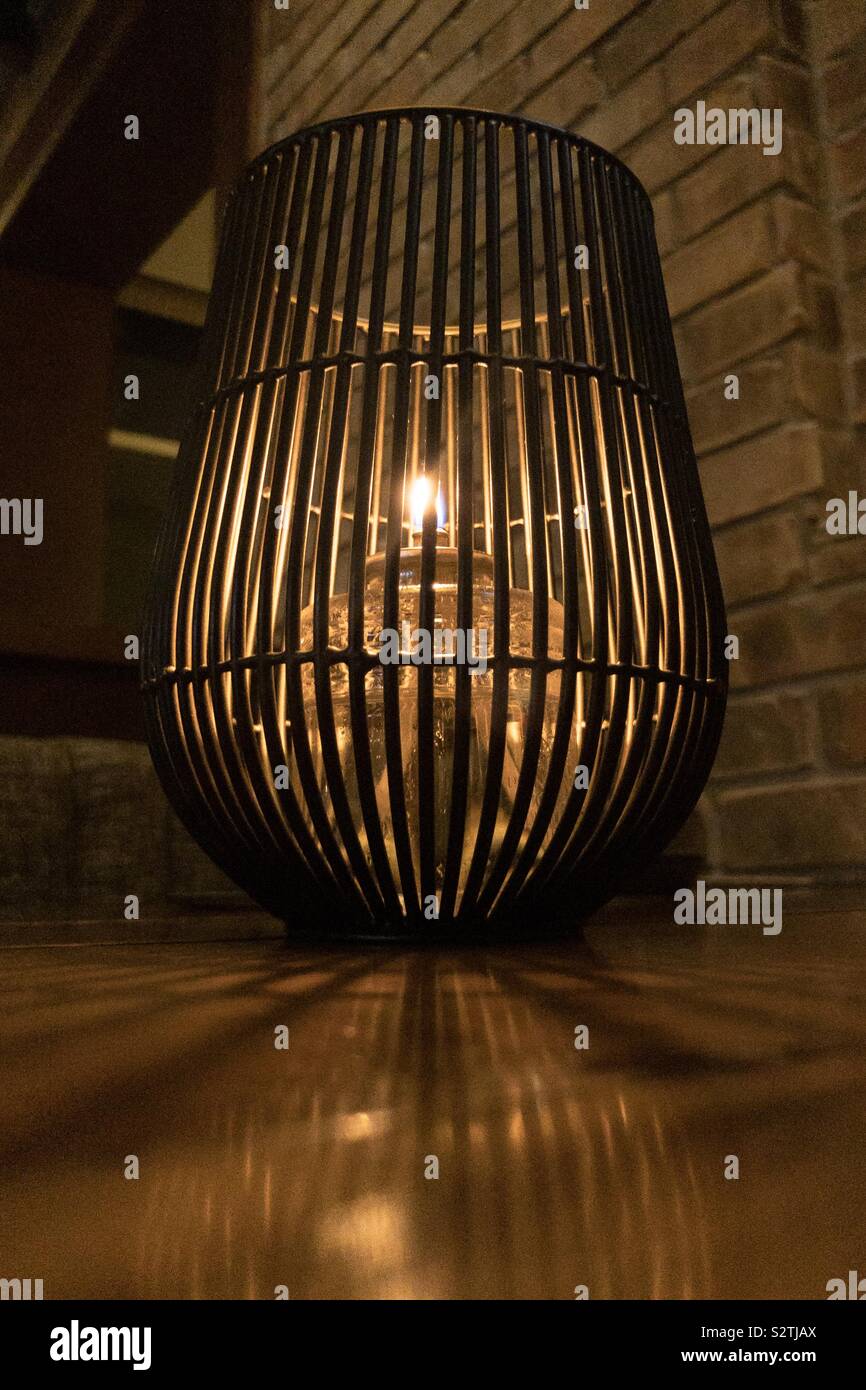 Oil style candle in black metal holder with reflection on the table - Smartphone Captured Stock Image
