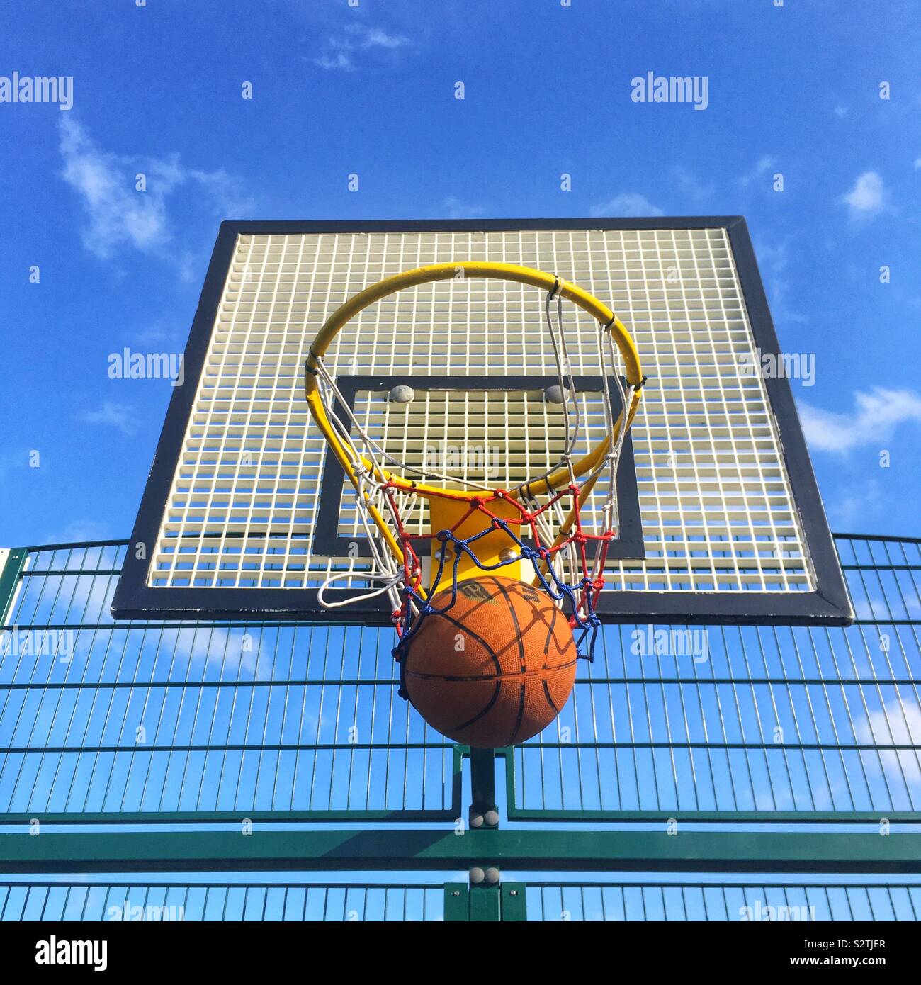 Basketball hoop with a basketball, Four Marks, Hampshire, England, United Kingdom. - Smartphone Captured Stock Image