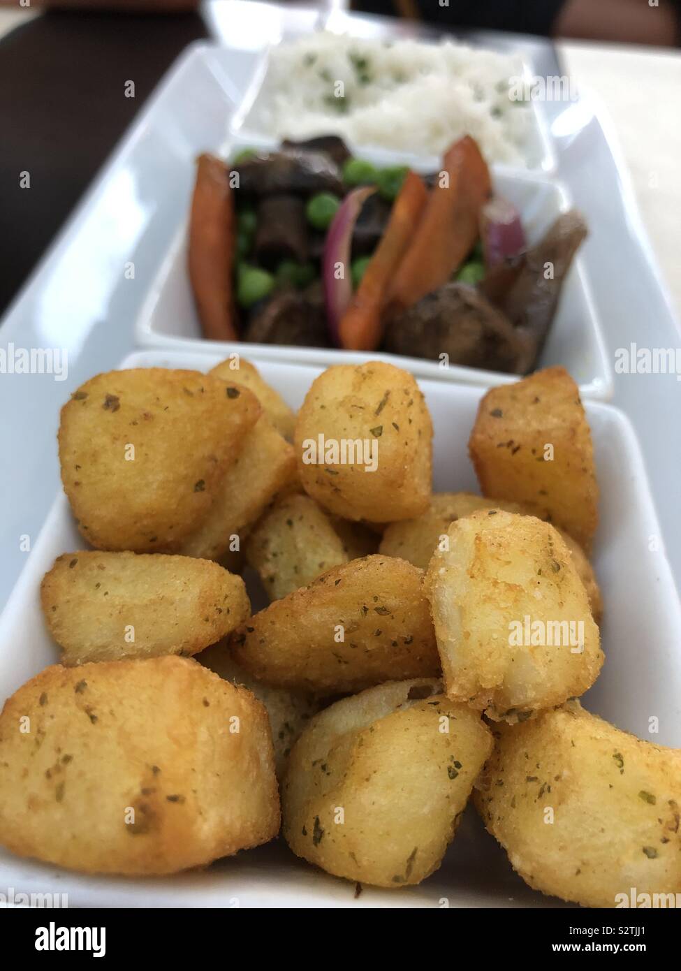 Patatas Bravas with vegetables and rice in a dish. Spain Stock Photo