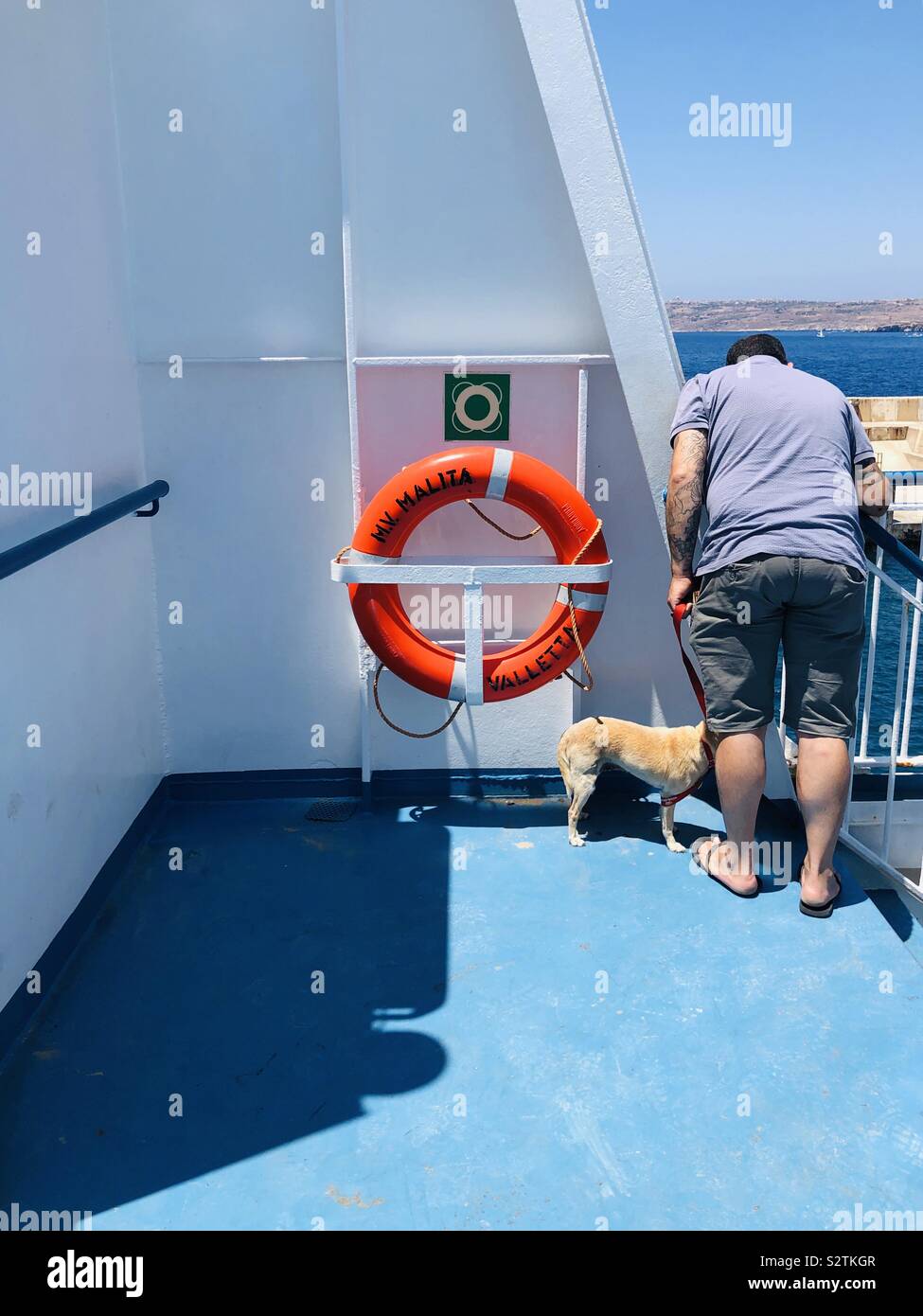 Man and dog on a ferry Stock Photo