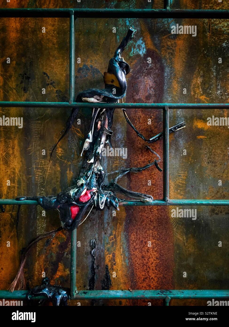 Burnt plastic and metal grating, Petaling Street Market, Kuala Lumpur, Malaysia - Smartphone Captured Stock Image