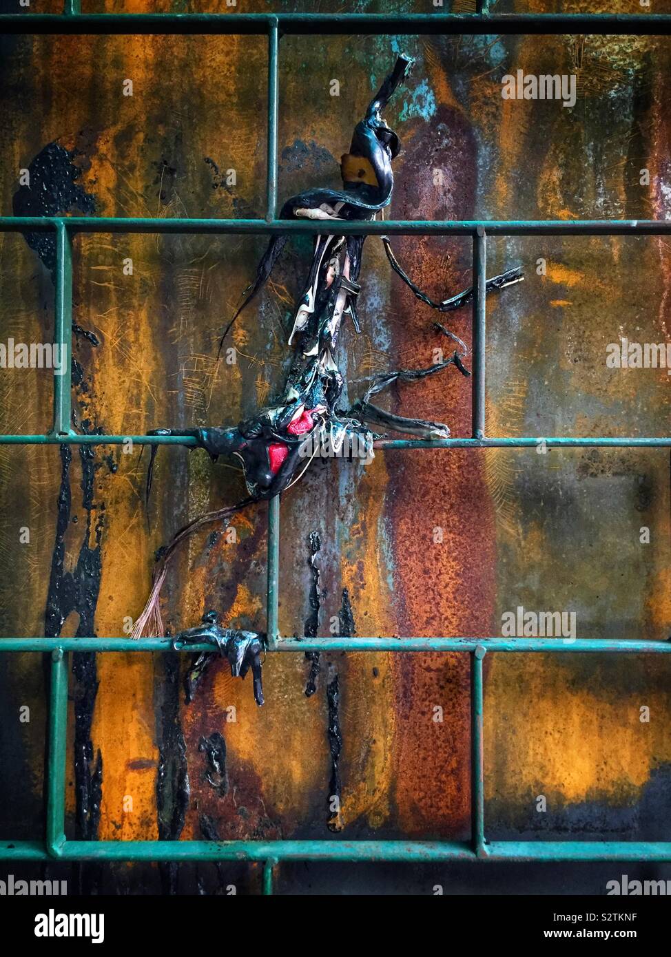Burnt plastic and metal grating, Petaling Street Market, Kuala Lumpur, Malaysia - Smartphone Captured Stock Image
