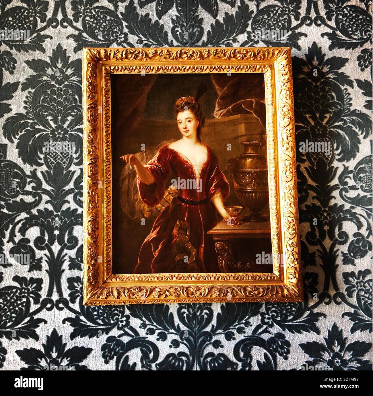 Portrait with gold ornate frame on decorative wallpaper, The Louvre Museum - Smartphone Captured Stock Image