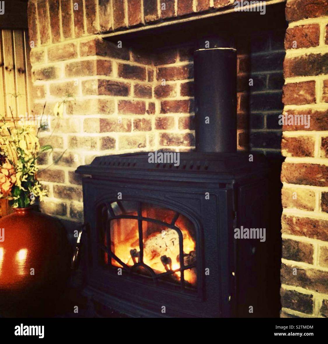 COSY decorating letters against a rustic brick wall above a wood burning  stove Stock Photo - Alamy