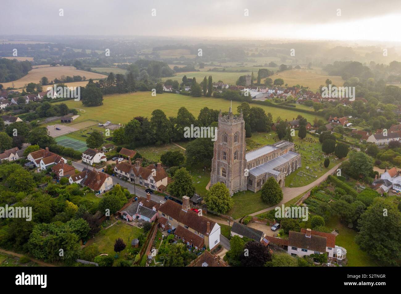 Aerial image of Stoke-by-Nayland church in Suffolk at sunrise. Stock Photo