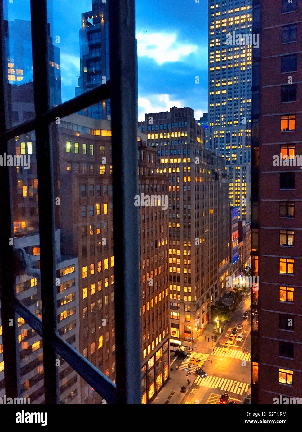 Desk scene of skyscrapers in midtown Manhattan along 34th St. through an apartment window, NYC, USA - Smartphone Captured Stock Image