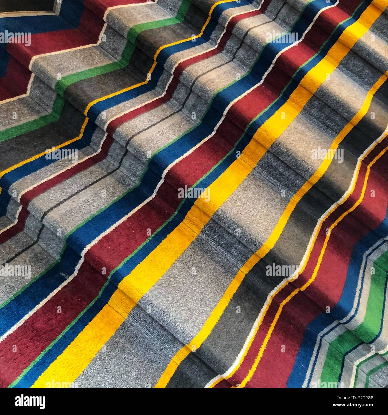 A stairway covered in a colorful striped carpet - Smartphone Captured Stock Image