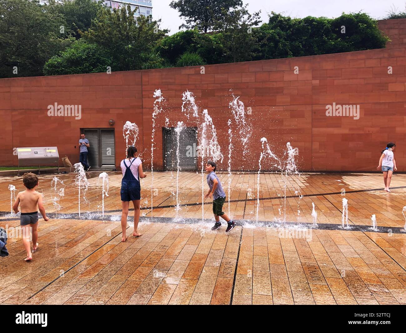 Summer fun with water fountains. Kids cooling off. Stock Photo