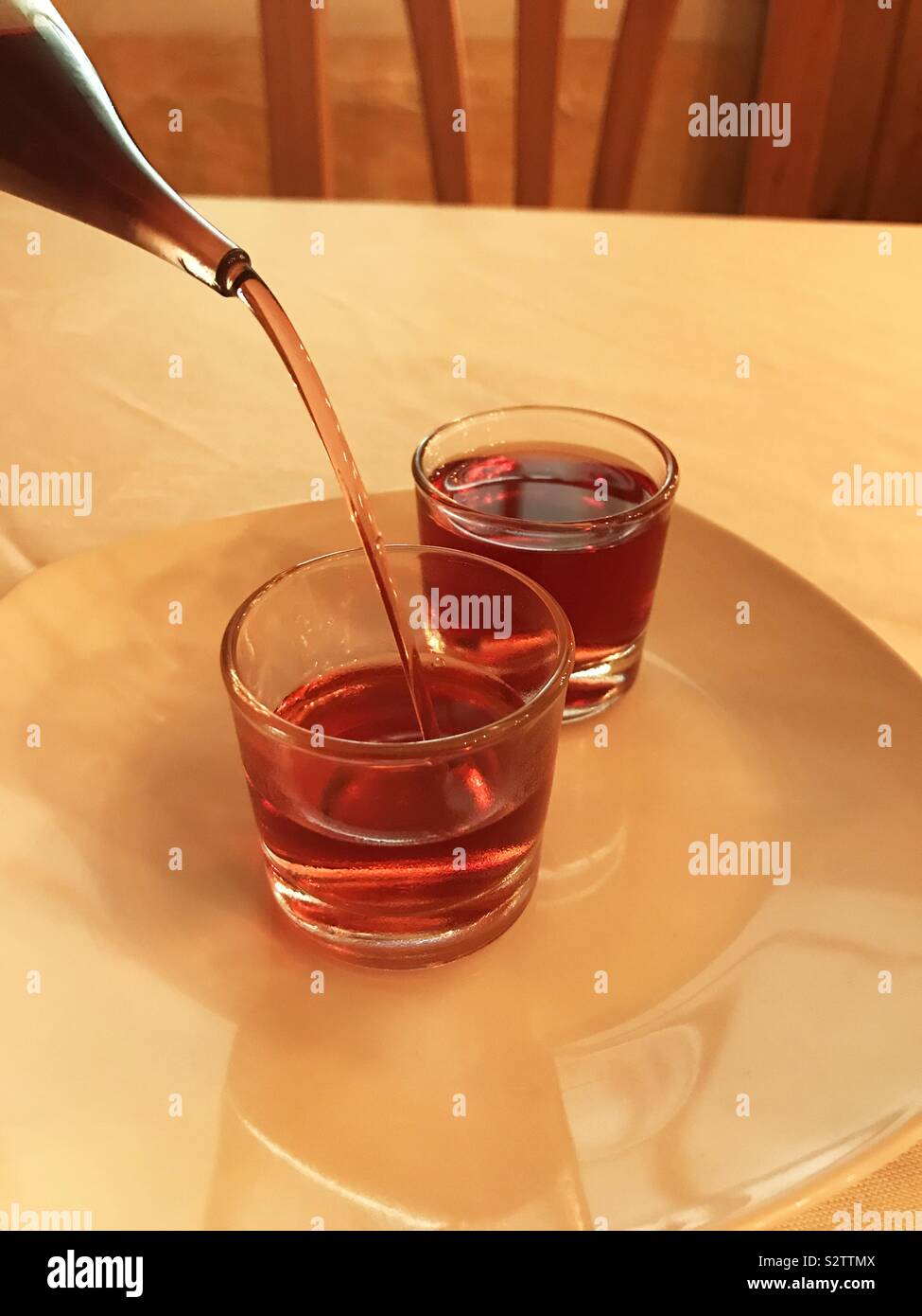 Pouring liqueur in two glasses Stock Photo