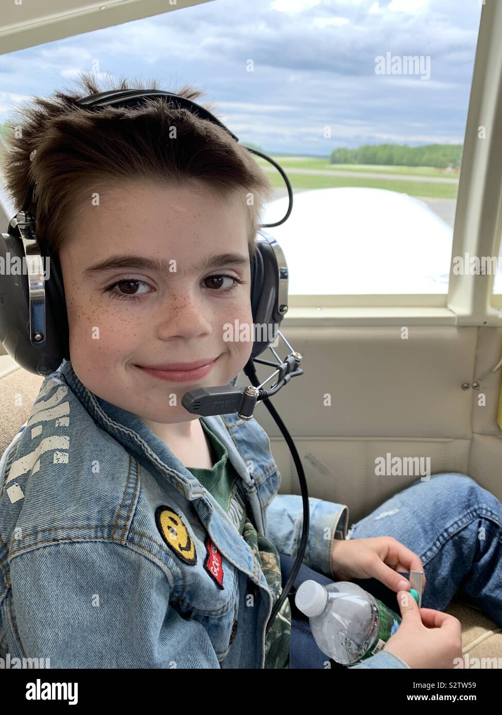 A nine year old boy gets a ride in a small plane. Stock Photo