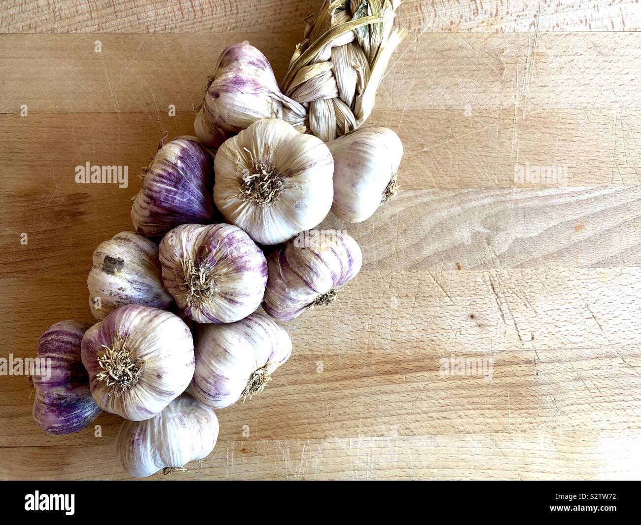 Garlic braid on a wooden background Stock Photo