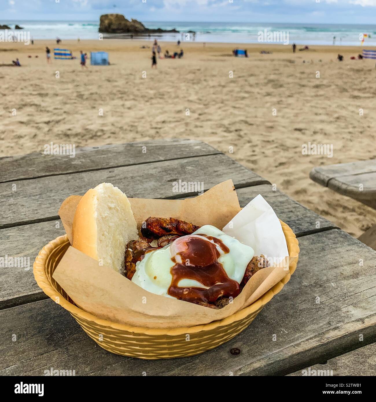 Sausage and egg butty in a bowl on the beach Stock Photo