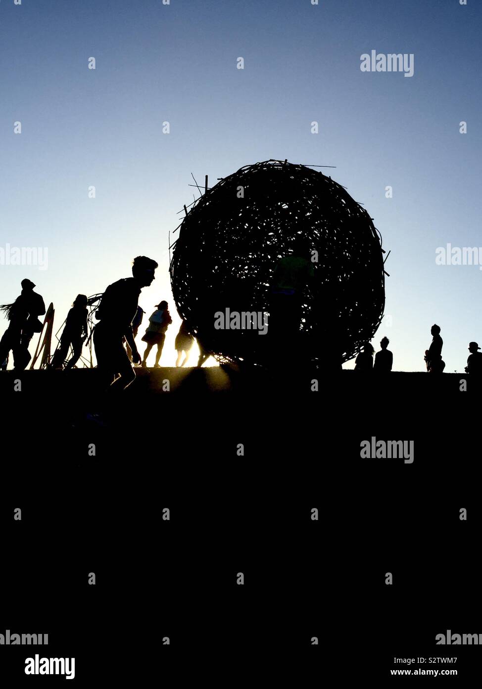 Sculpture by the sea Bondi to Tamarama coastal walk. Shadow figures around large woven sphere Stock Photo