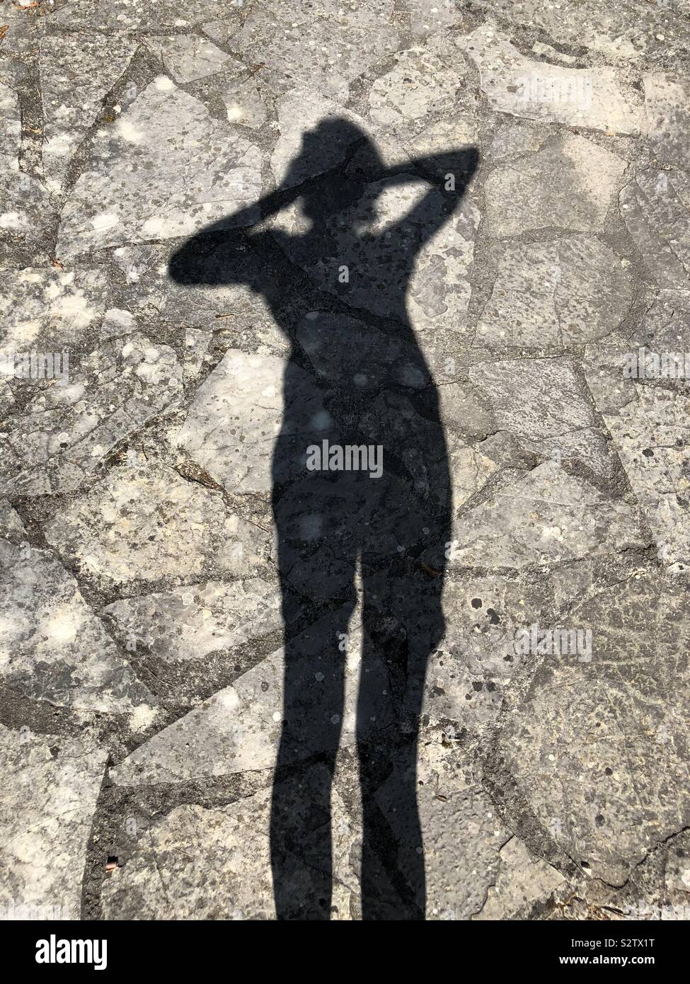 Shadow of woman on crazy paving Stock Photo