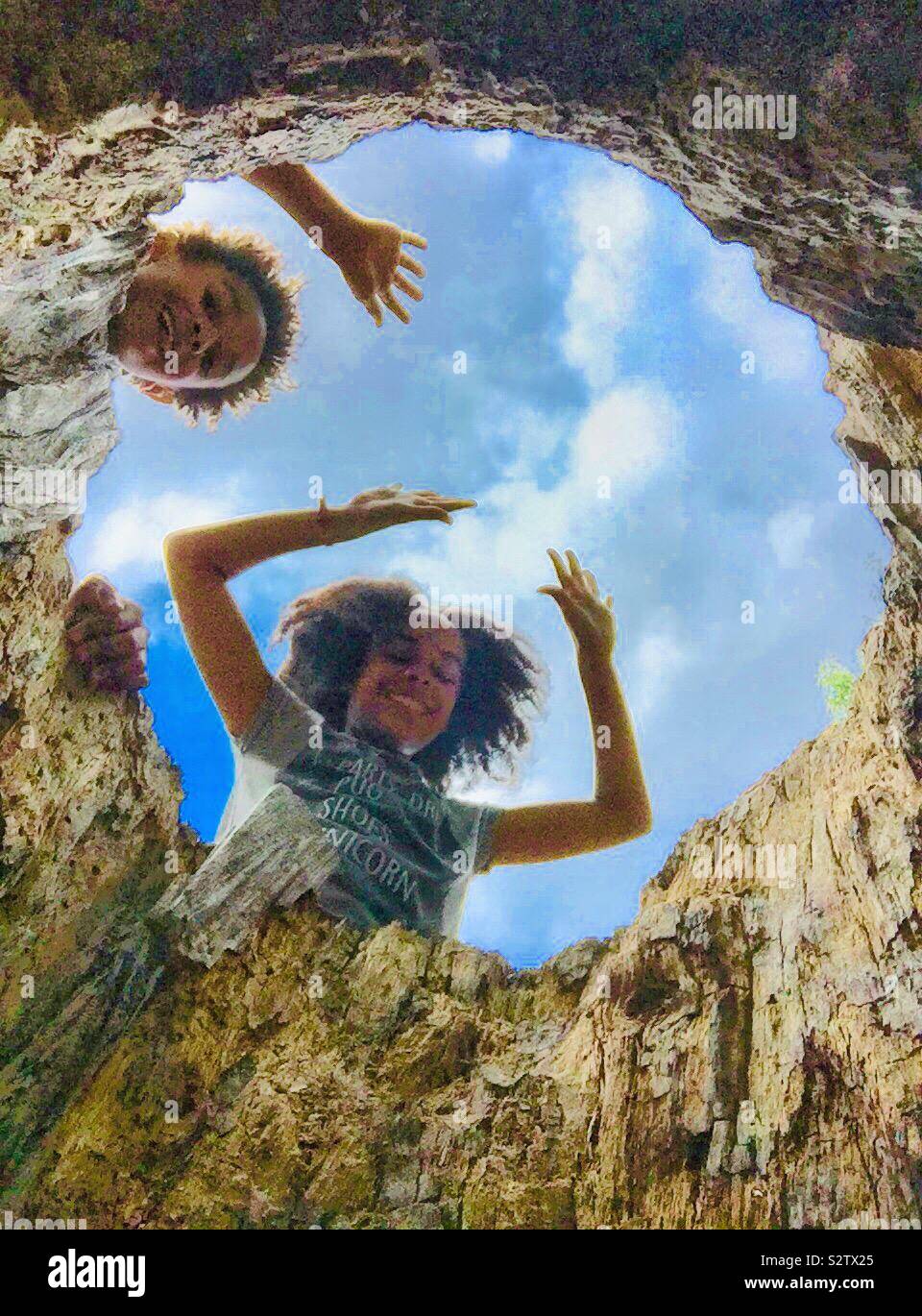 Children playing on a tree stump. - Smartphone Captured Stock Image