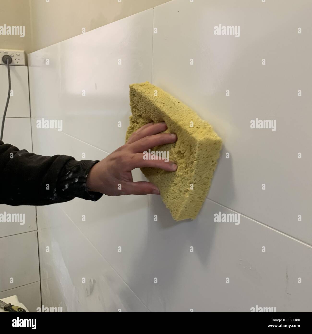 Man cleaning new bathroom tiles Stock Photo - Alamy
