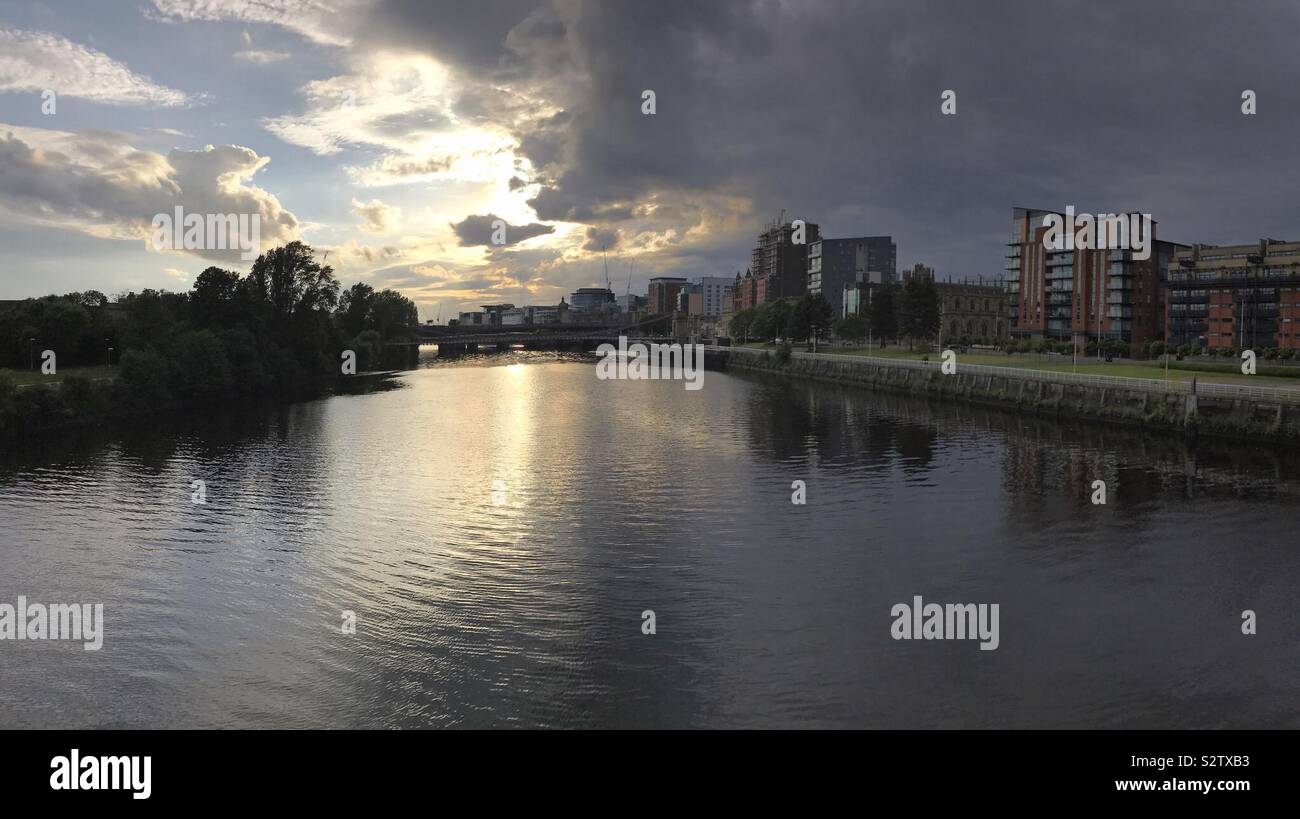 Glasgow, Scotland - June 8, 2019: River Clyde is shown in a panoramic view during the early evening. Modern buildings are shown along the riverscape, as well as brides crossing the waterway. Stock Photo