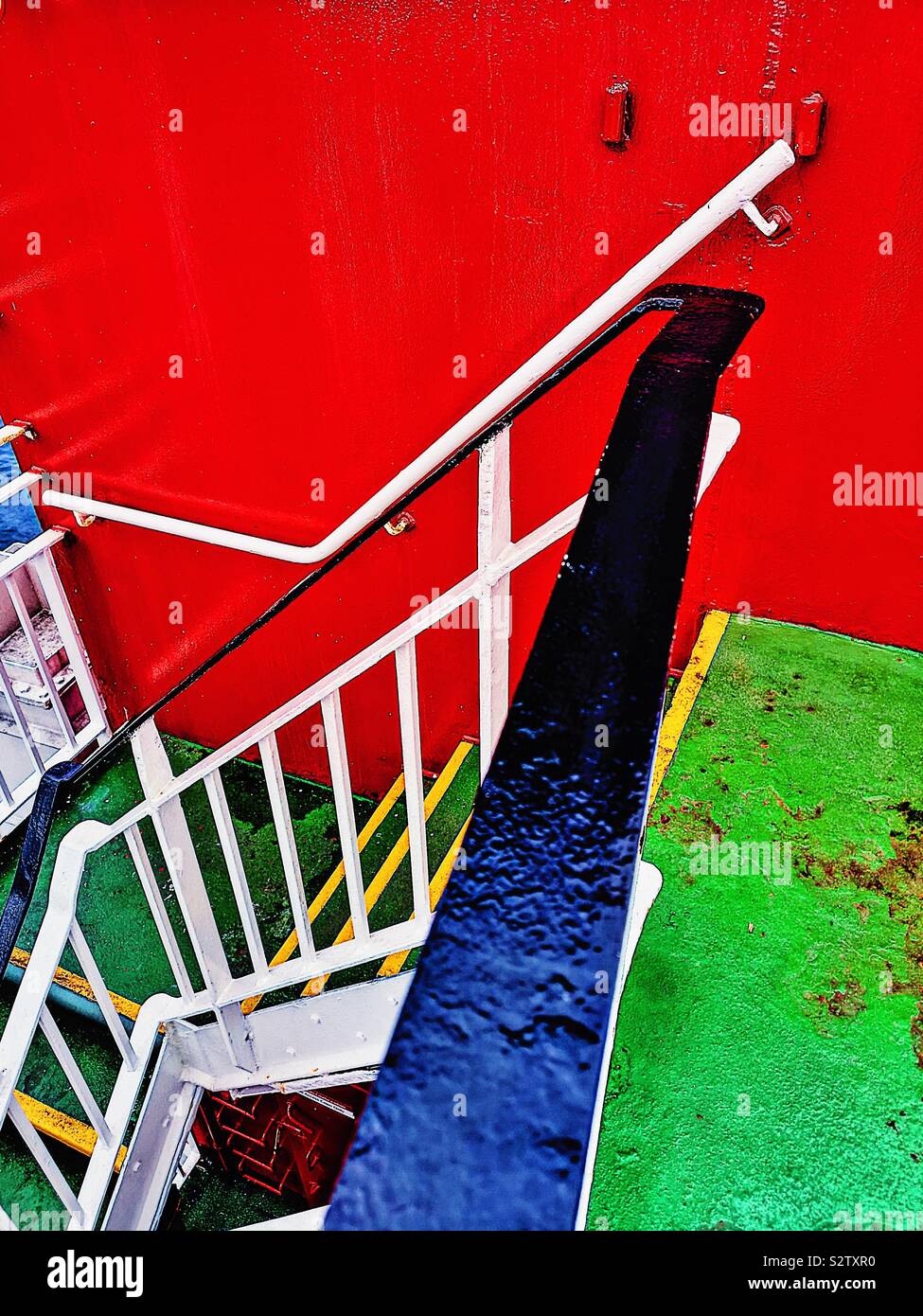 Red and green steps between ships decks next to vibrant red funnel - Smartphone Captured Stock Image
