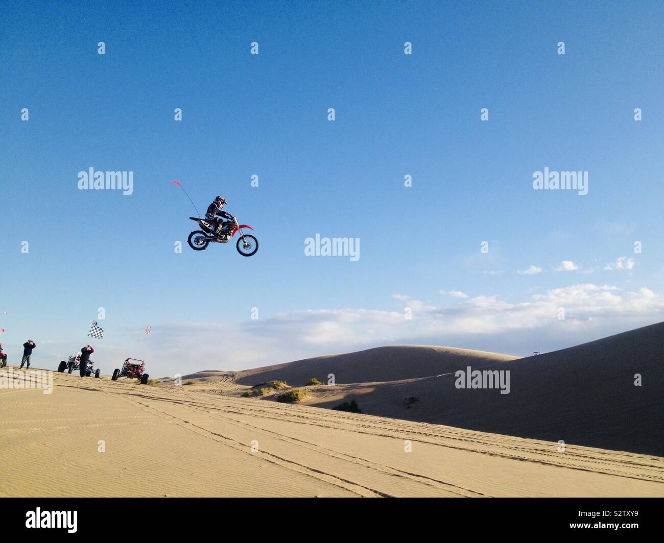 Dirt bike jumping in sand dunes Stock Photo Alamy