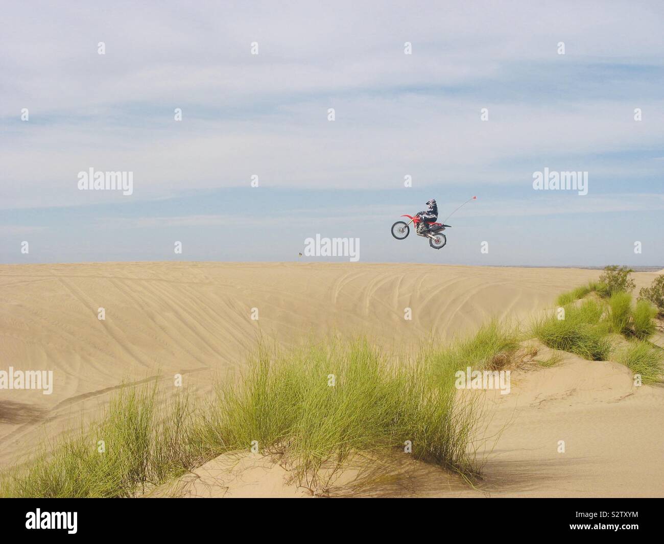Motorcycle jumping in the sand dunes Stock Photo Alamy