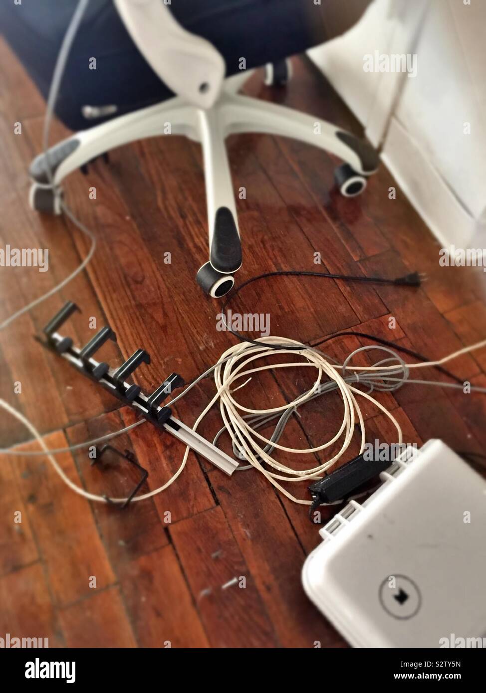 Tangled mess of electrical cords under an office chair, United States - Smartphone Captured Stock Image