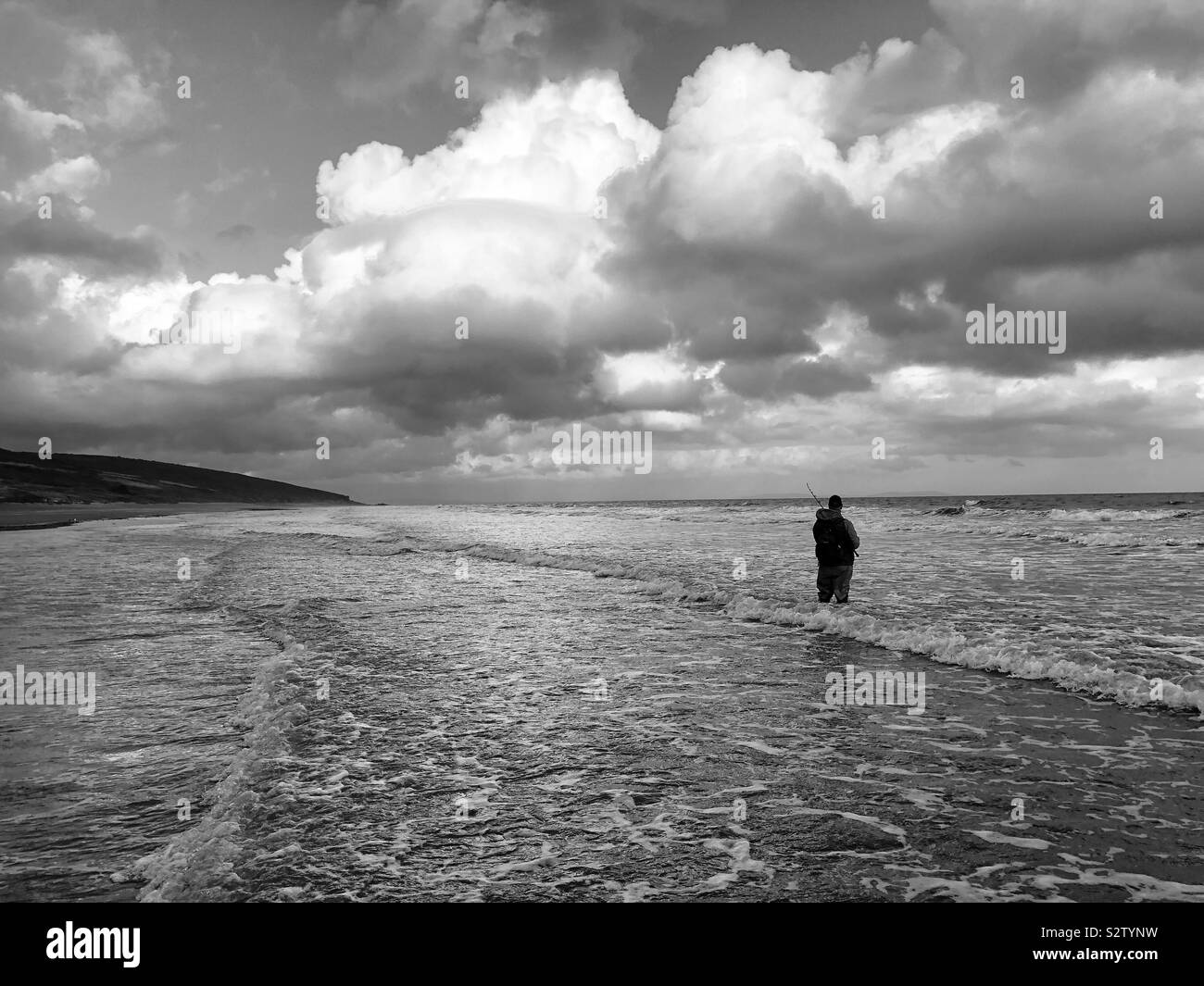 Lone bass angler in the surf on a Welsh surf beach, August. - Smartphone Captured Stock Image