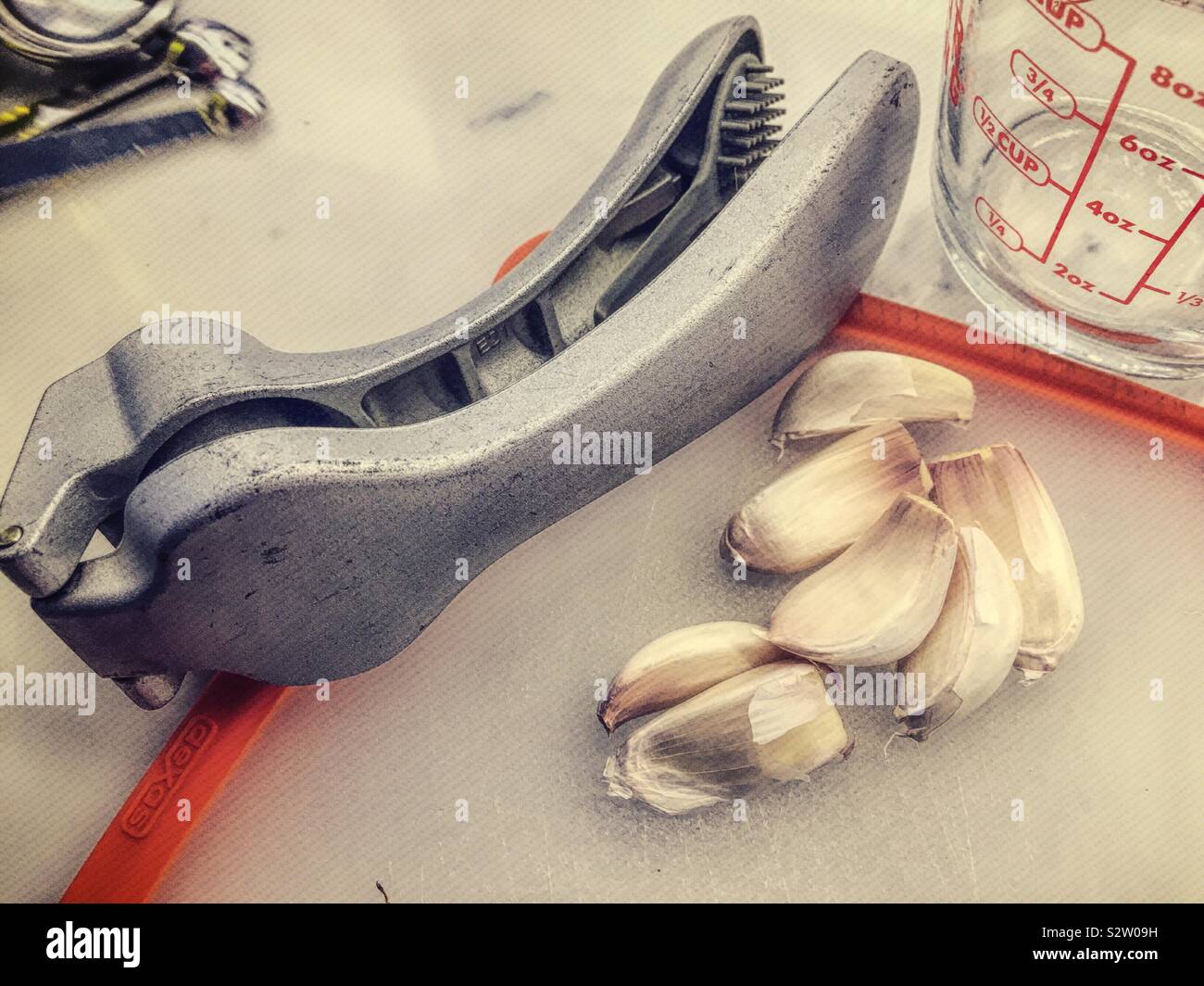 Garlic cloves and garlic press on a residential kitchen counter, USA - Smartphone Captured Stock Image
