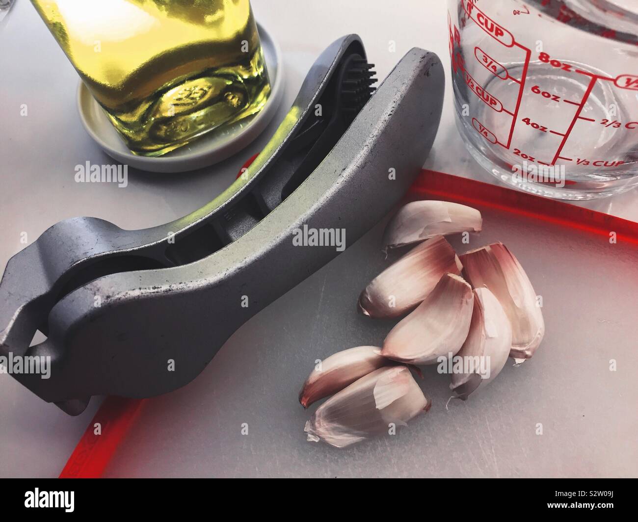 Garlic cloves and press on a residential kitchen counter, USA - Smartphone Captured Stock Image