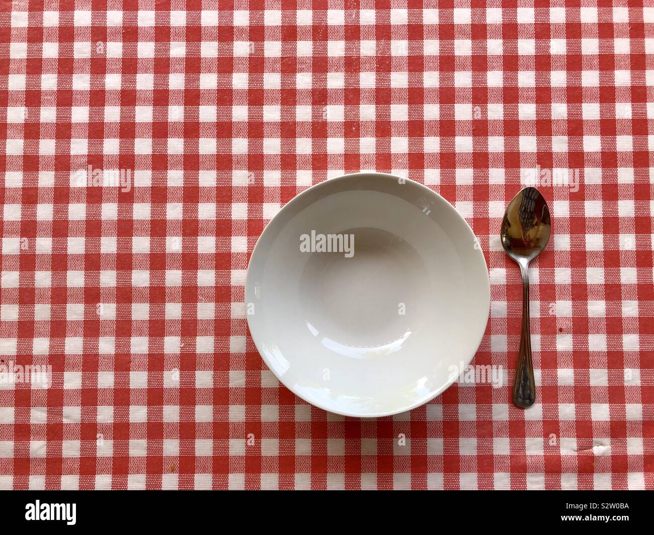 Plate and spoon on checked table cloth - Smartphone Captured Stock Image