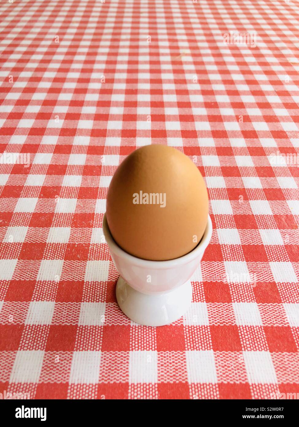 Egg in an egg cup on red and white background Stock Photo