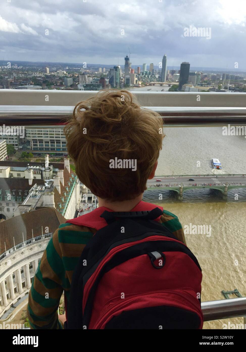 Toddler on London August 2019 wearing red backpack and looking at skyline view. - Smartphone Captured Stock Image