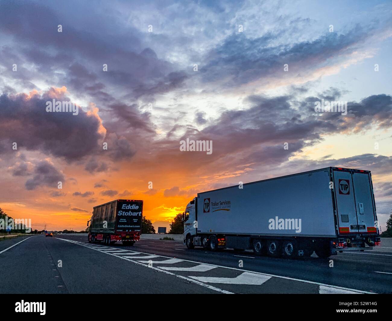 HGV lorries on M62 motorway during summer sunset Stock Photo