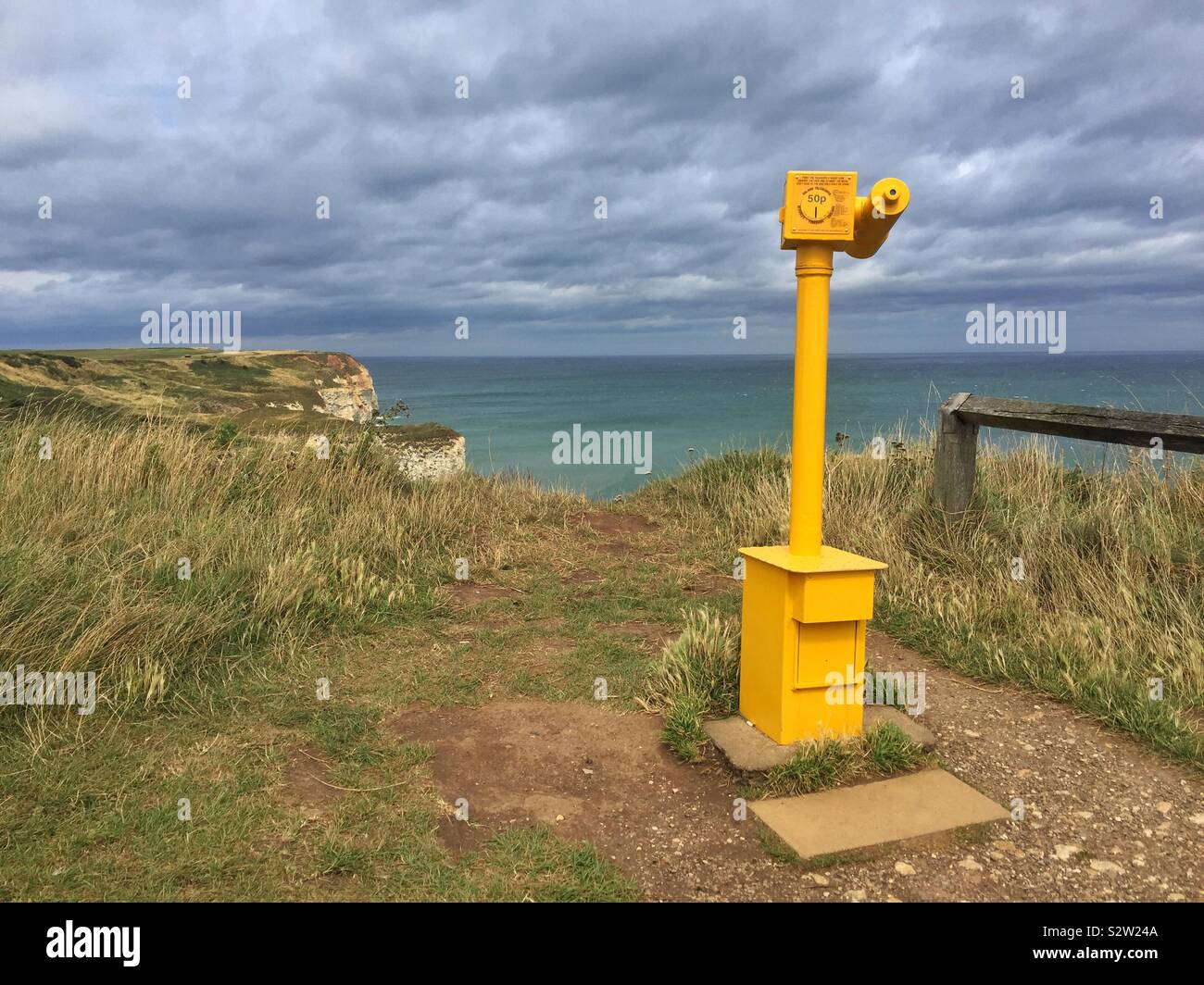 A viewing telescope at Flamborough Head looking out to sea with chalk cliffs in the scene. - Smartphone Captured Stock Image