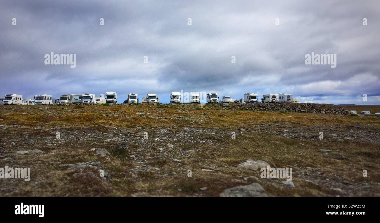 Camper vehicles lined up in a barren field in Nordkapp (North Cape), Norway, the northernmost point in Europe accessible by car Stock Photo