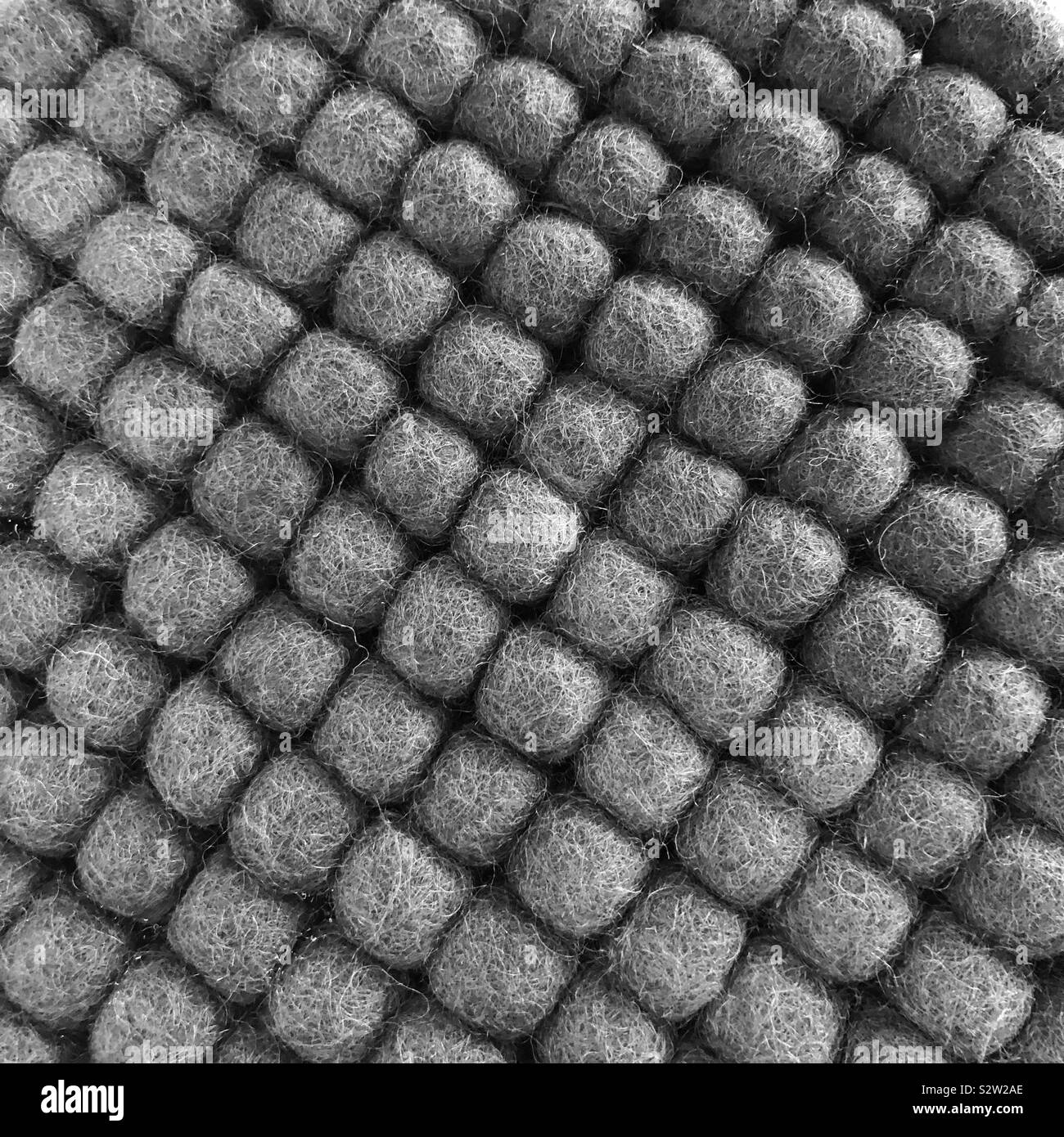 A closeup of grey wool balls lined up in diagonal rows - Smartphone Captured Stock Image