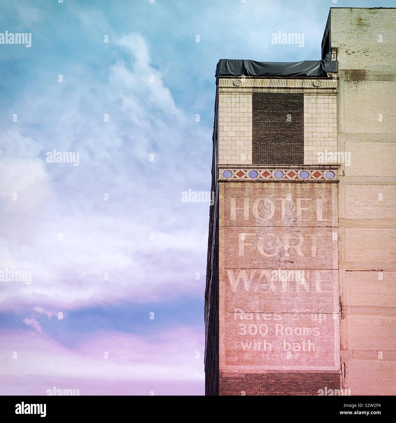 An old ghost sign on the back of the Detroit Masonic Temple that reads “Hotel Fort Wayne” against a cloudy pastel sky - Smartphone Captured Stock Image An old ghost sign on the back of the Detroit Masonic Temple that reads “Hotel Fort Wayne” against a cloudy pastel sky - Smartphone Captured Stock Image