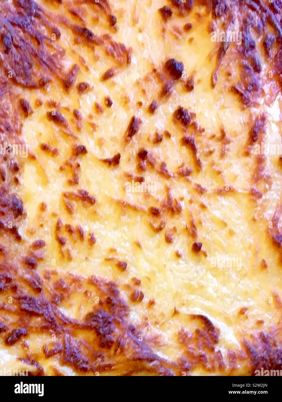 Top of a baked lasagne. Golden, oven cooked, melted cheese Stock