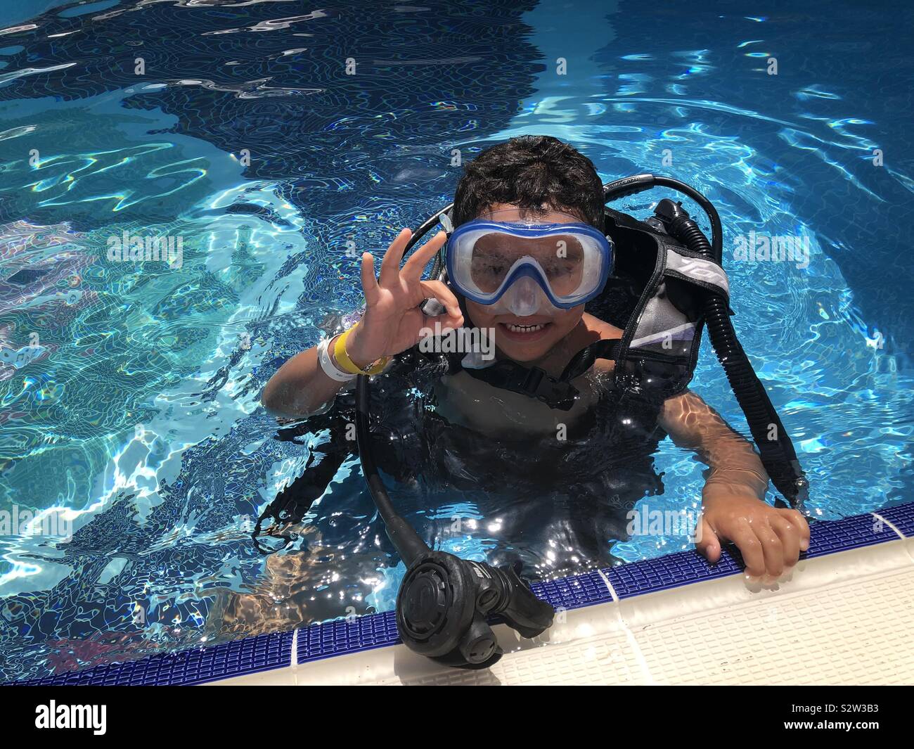 Little boy learning to scuba dive in pool Stock Photo