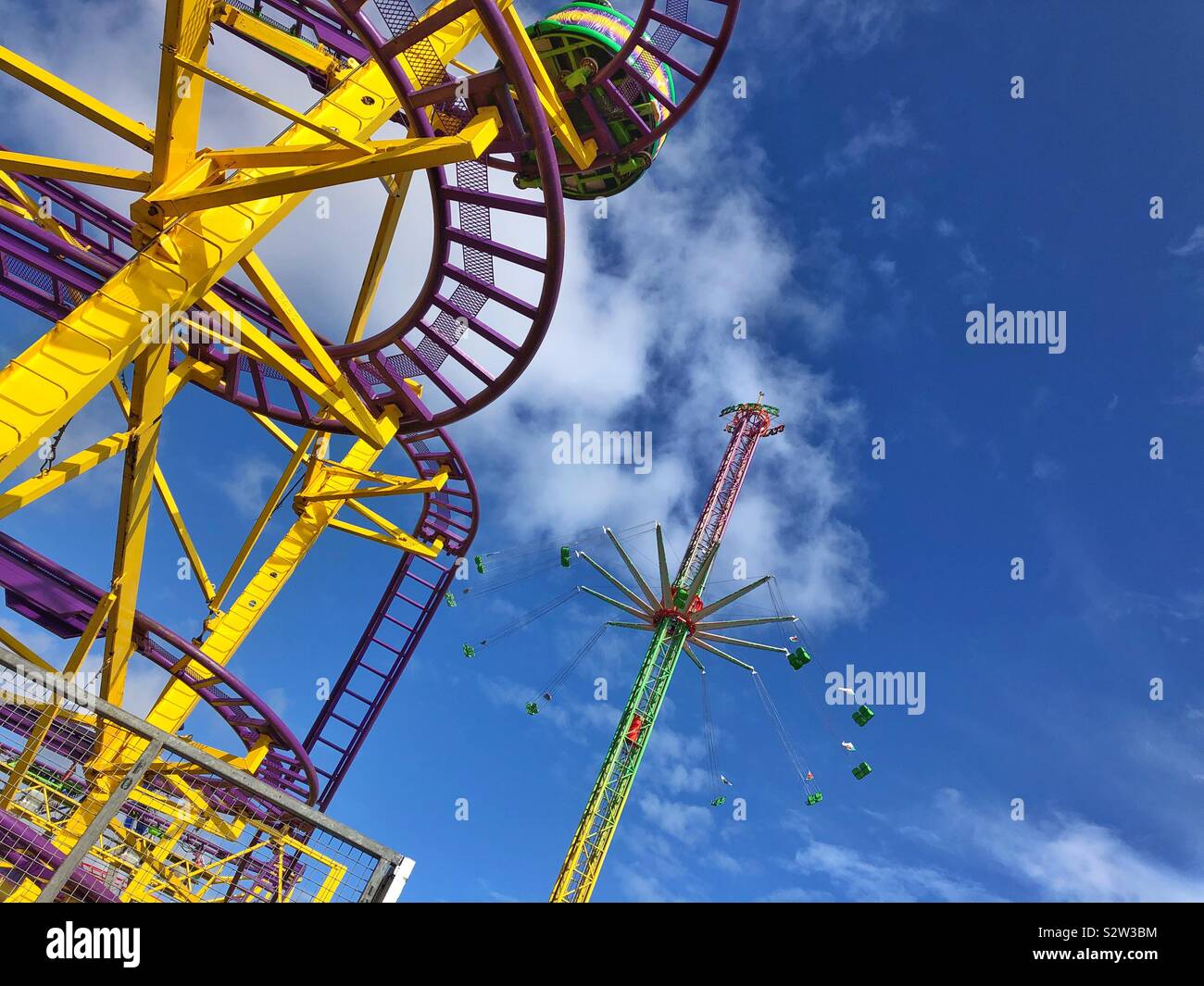 Wild Mouse roller coaster and Star Flyer chair ride at Barry Island Pleasure Park, South Wales. - Smartphone Captured Stock Image