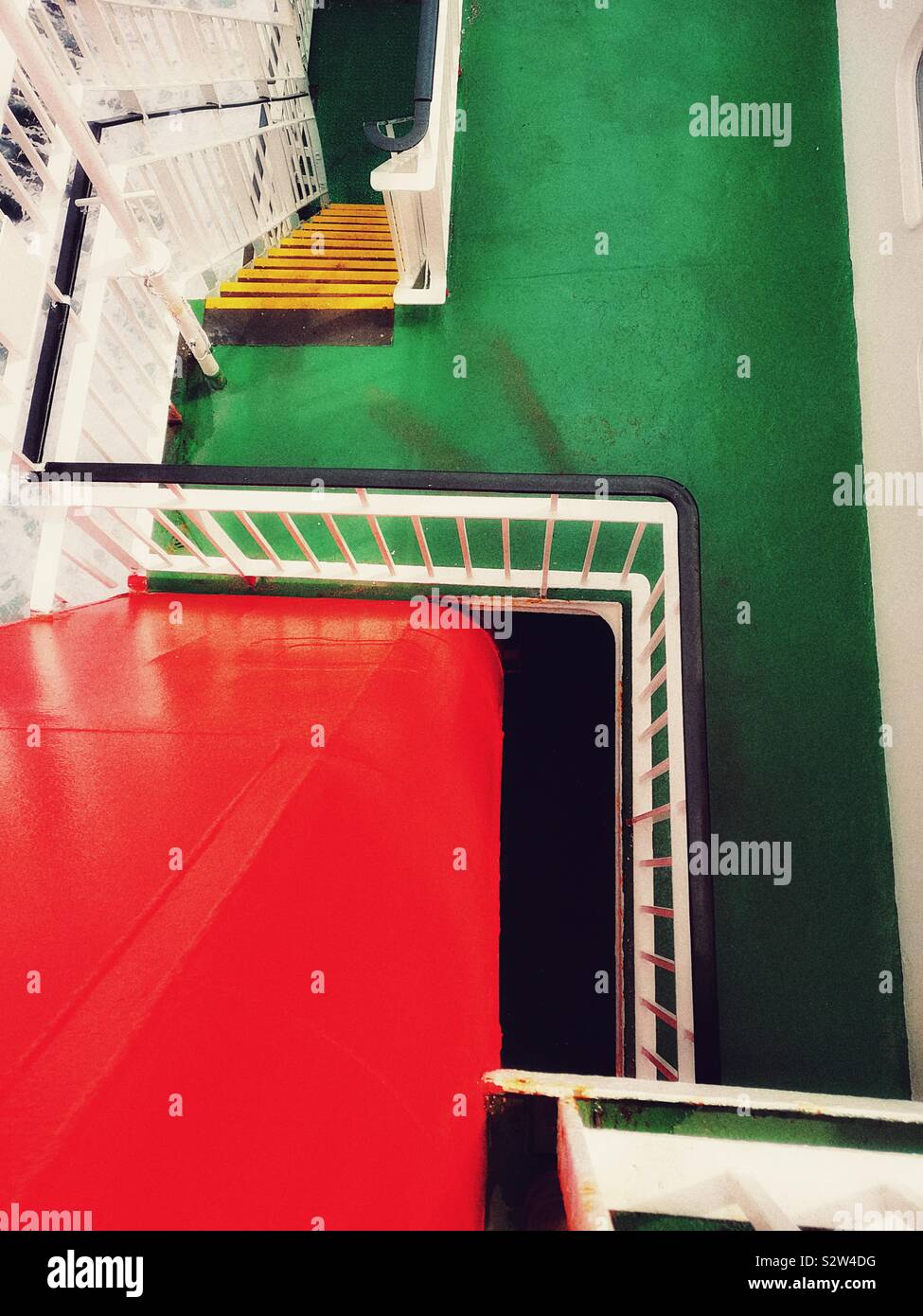 Red ships funnel and colourful stairways between decks on ship - Smartphone Captured Stock Image