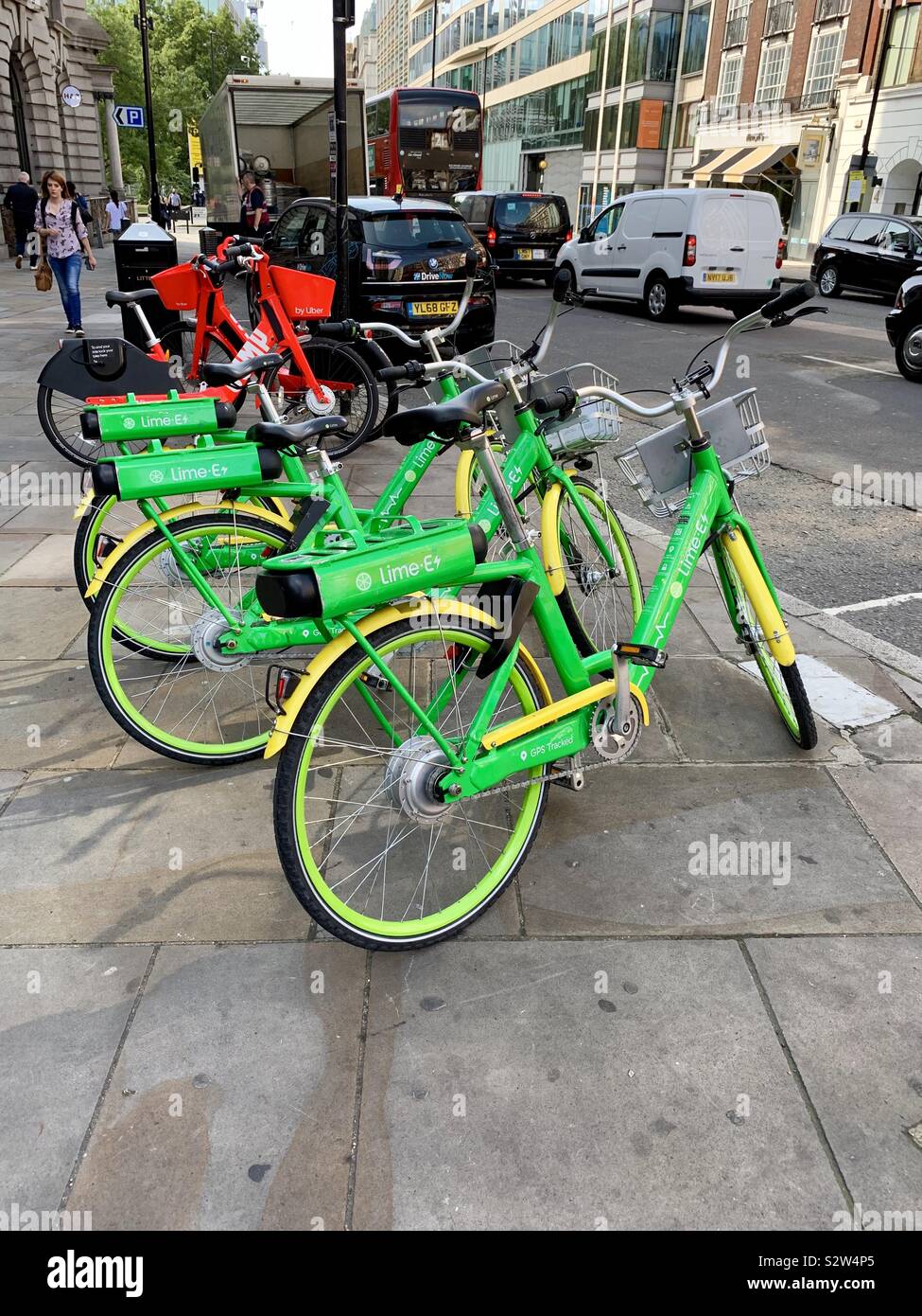 London, UK - 13 August 2019: Bright green and yellow Lime electric rental bikes beside City Road, Islington. - Smartphone Captured Stock Image