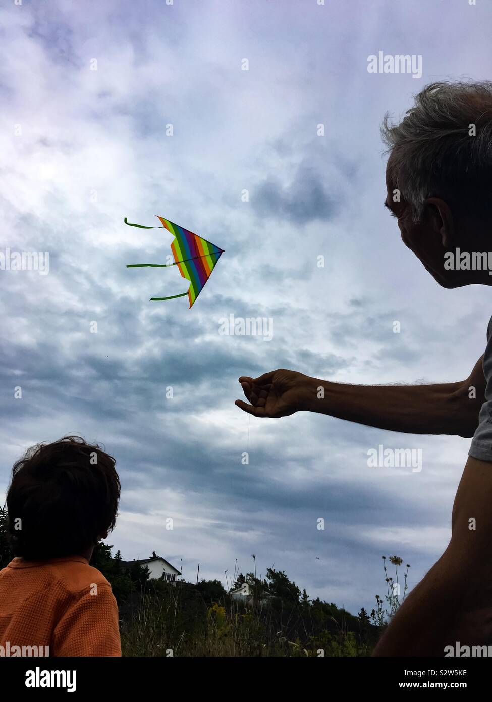 Old and young flying a kite Stock Photo