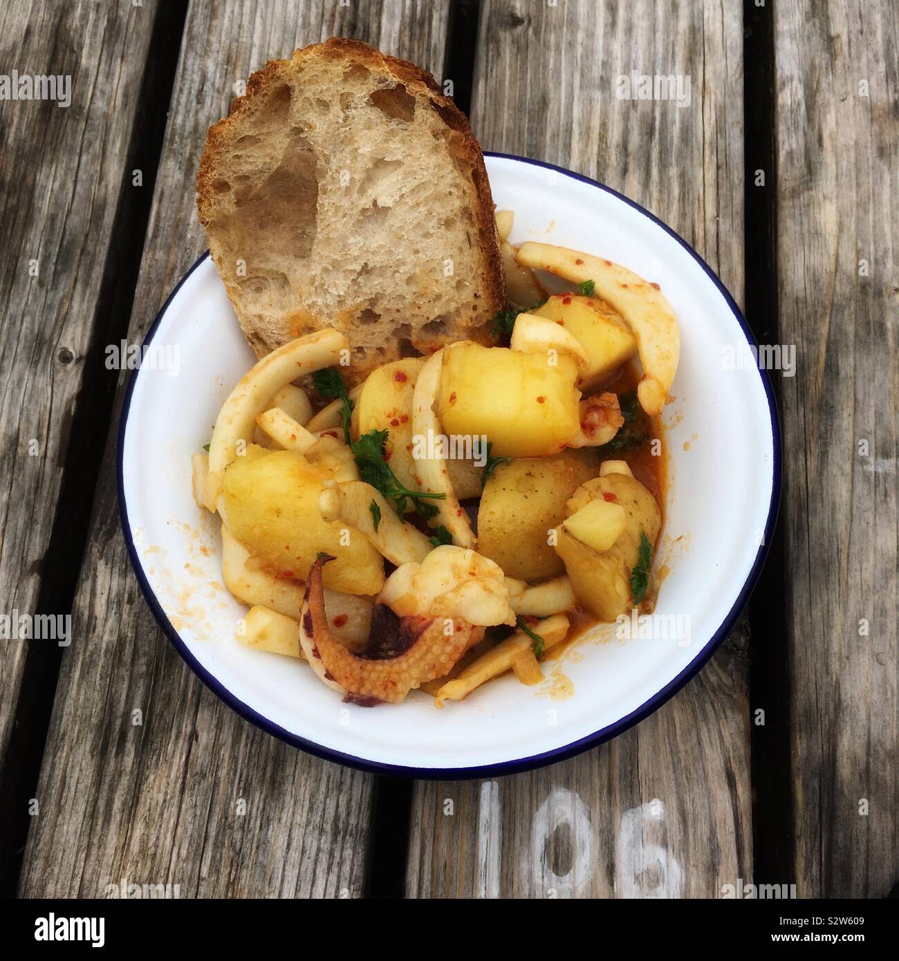 Bowl of cuttlefish with chilli and new potatoes, Devon, England, United Kingdom. - Smartphone Captured Stock Image