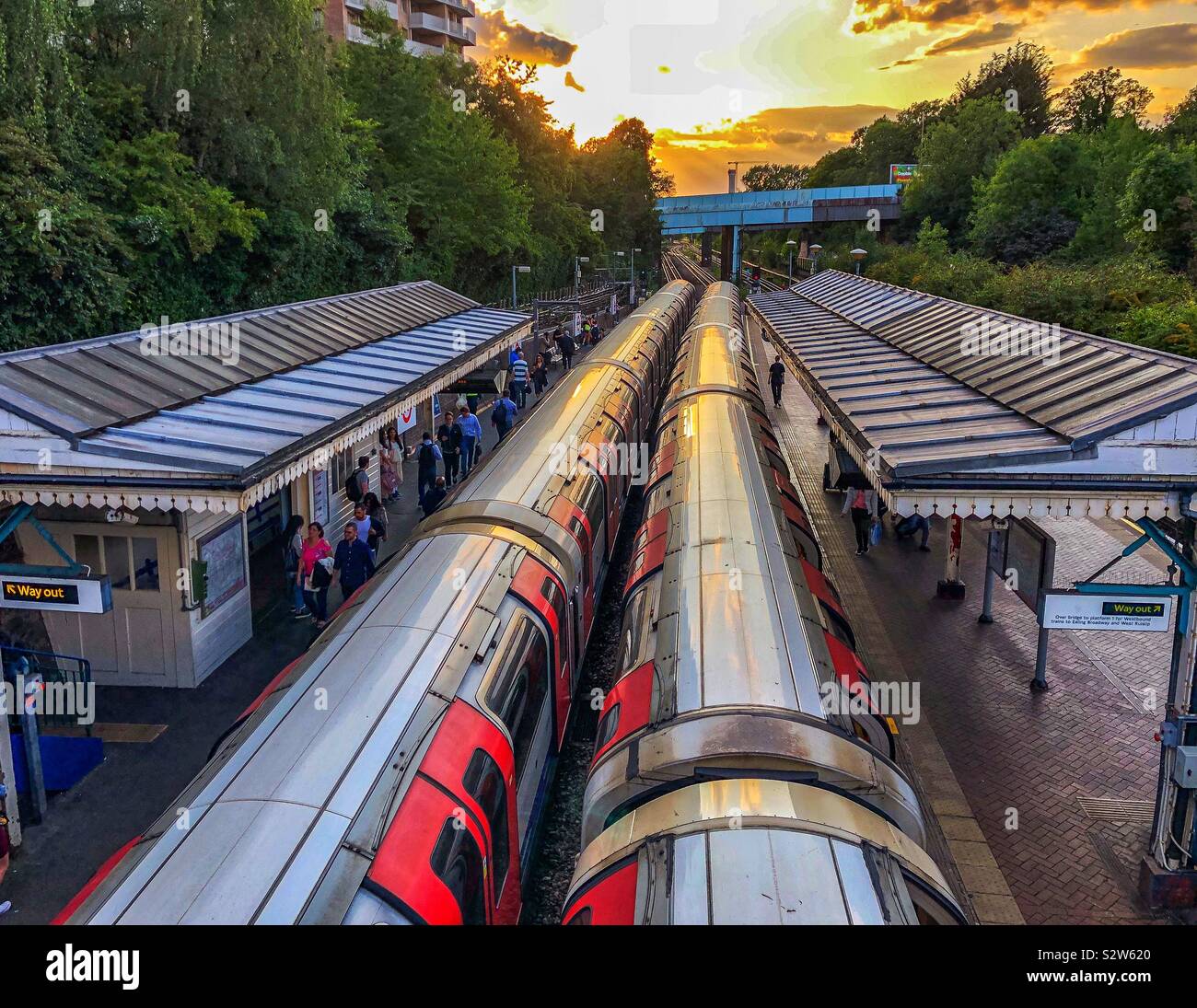 North Acton London Underground tube train station in a summer sunset. Two trains at the station. Stock Photo