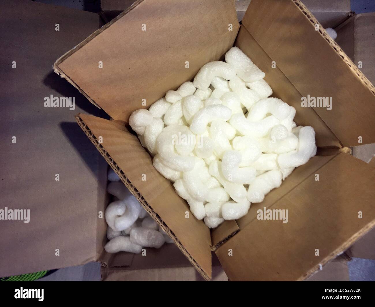 Close up of a cardboard packing box filled with white Styrofoam peanuts, USA - Smartphone Captured Stock Image