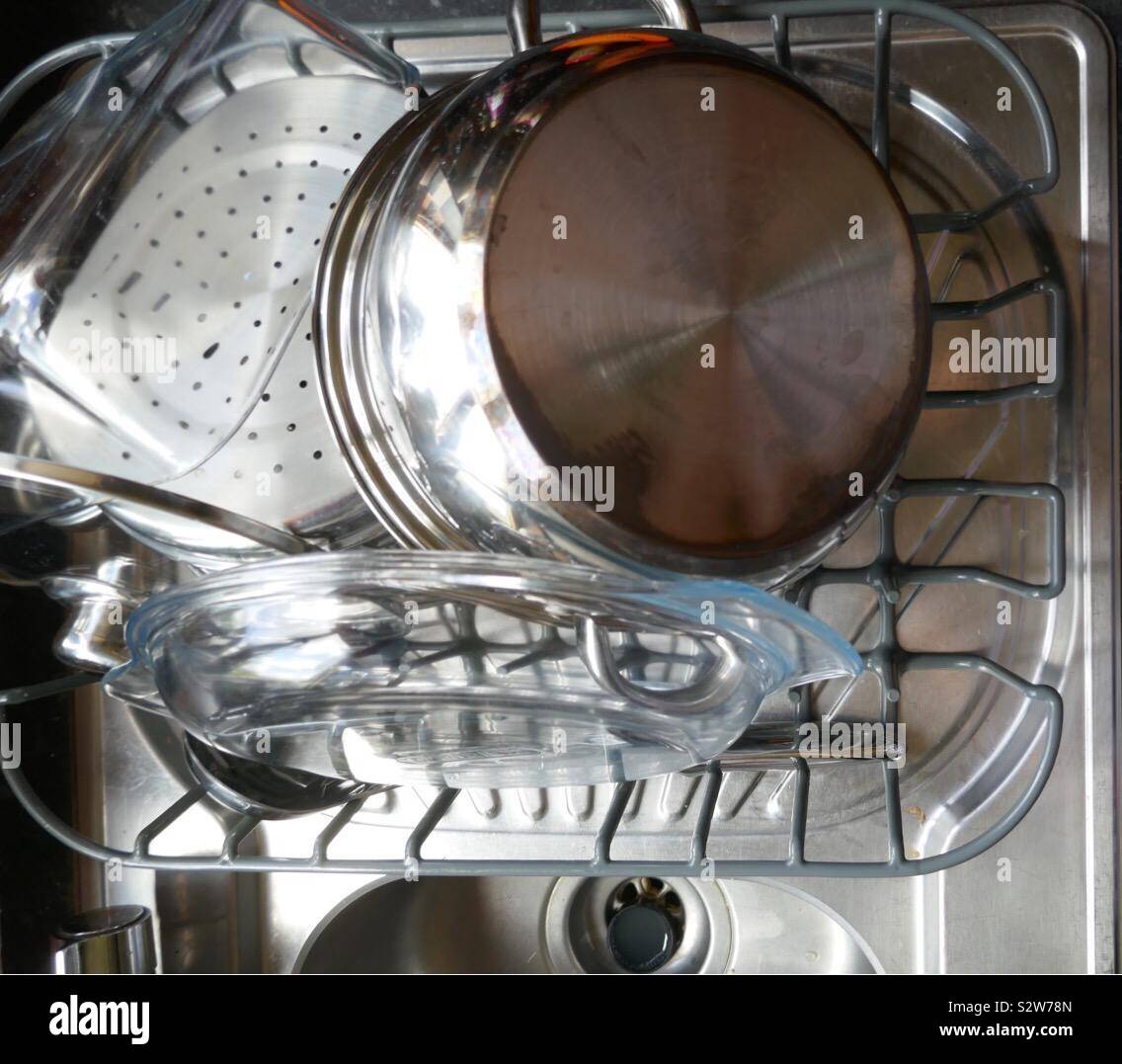 Washing up drying on a draining board next to a stainless steel sink