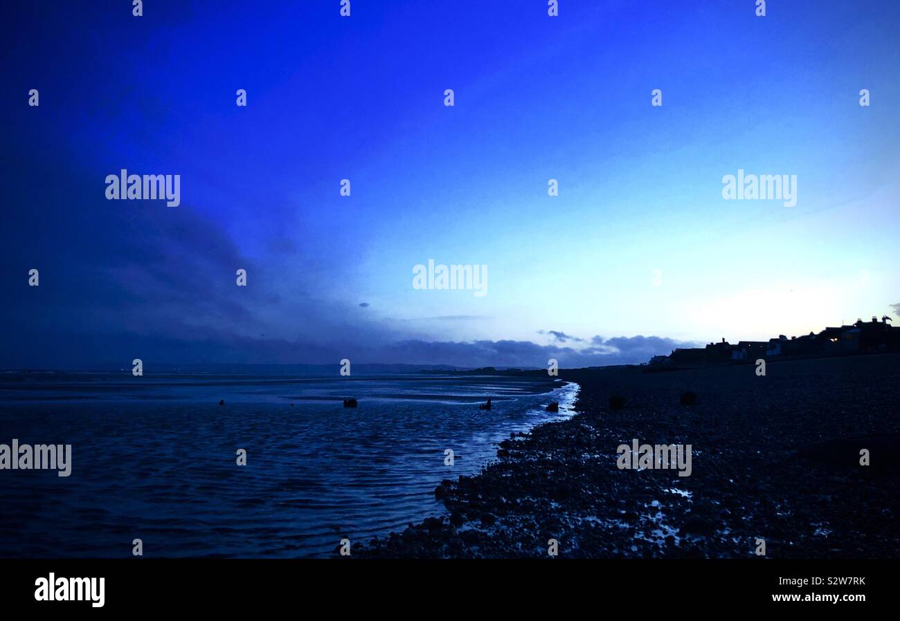 Dark blue clouds over a cold empty beach - Smartphone Captured Stock Image