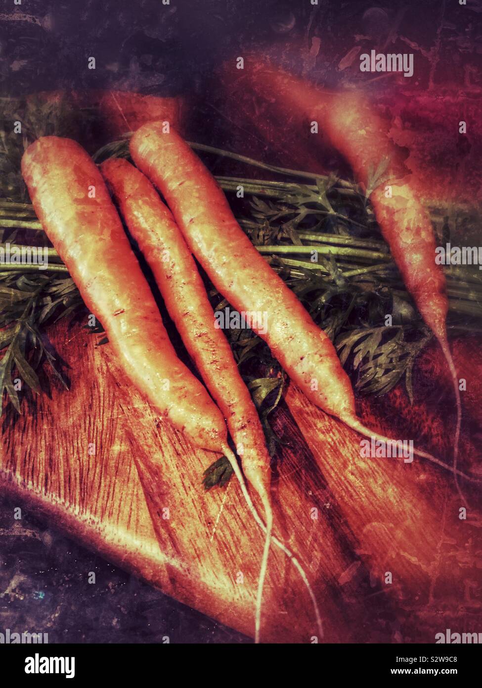 Grunge effect carrots on a chopping board Stock Photo